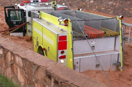 Arrastra arroyo a unidad con cuatro bomberos