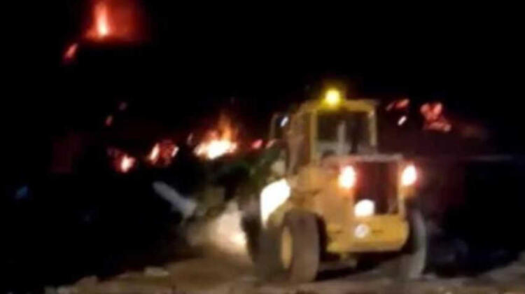 Bomberos intentan encauzar la lava con un tractor